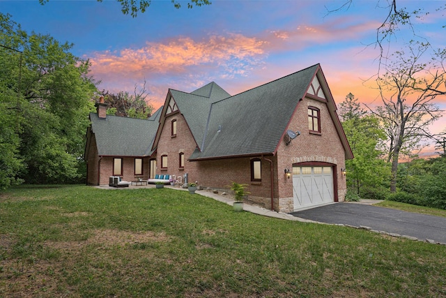 557 Signal Hill Rd, North Barrington, IL 60010 - tudor house featuring brick siding, roof with shingles, a lawn, a chimney, and driveway