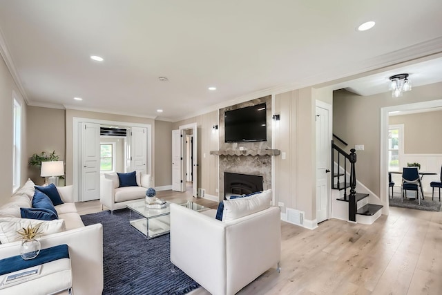 living room with stairs, ornamental molding, light wood-style floors, baseboards, and recessed lighting