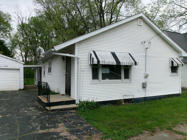 827 Canal St, Marseilles, IL 61341 - view of side of home featuring an outdoor structure, asphalt driveway, and a detached garage