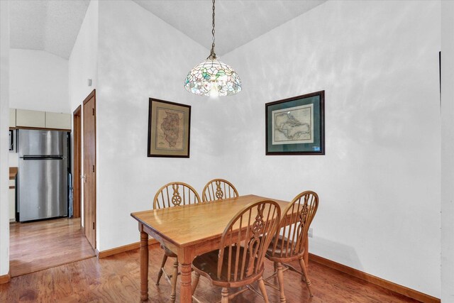 2805 Susan Stone Dr, Urbana, IL 61802 - dining area featuring vaulted ceiling, baseboards, and light wood-style floors