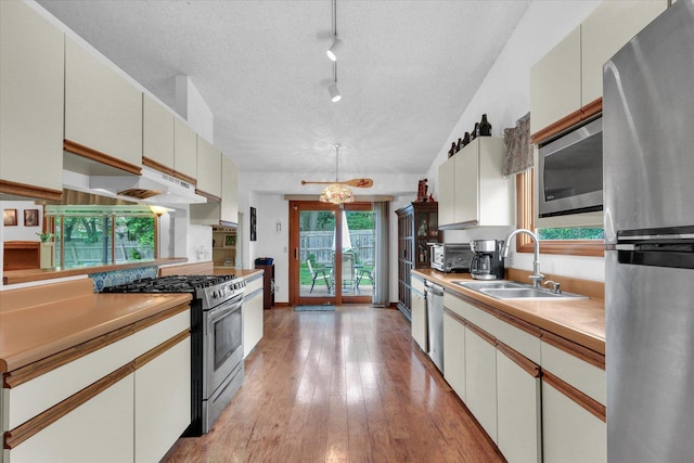 2805 Susan Stone Dr, Urbana, IL 61802 - kitchen featuring appliances with stainless steel finishes, a sink, light countertops, light wood-style flooring, and a textured ceiling