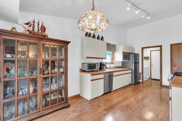 2805 Susan Stone Dr, Urbana, IL 61802 - kitchen featuring appliances with stainless steel finishes, washer / clothes dryer, light wood-style flooring, track lighting, and a sink