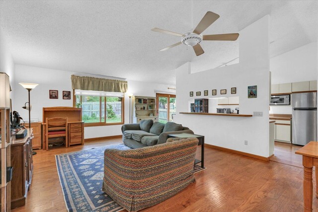 2805 Susan Stone Dr, Urbana, IL 61802 - living room with a ceiling fan, a textured ceiling, wood finished floors, high vaulted ceiling, and baseboards