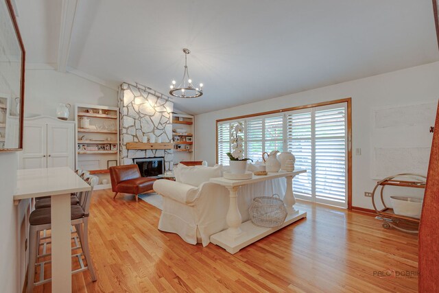 6316 Lake Shore Dr, Cary, IL 60013 - living area with light wood-style flooring, a stone fireplace, a chandelier, and baseboards