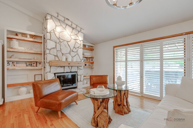 6316 Lake Shore Dr, Cary, IL 60013 - living room featuring vaulted ceiling, wood finished floors, a stone fireplace, and built in features