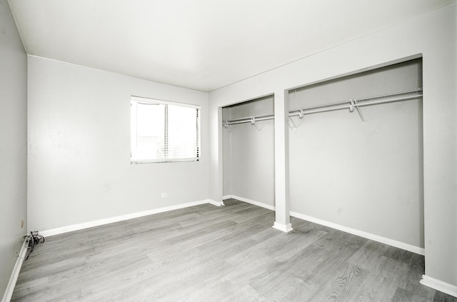 12741 S Lacrosse Ave Unit 3A, Alsip, IL 60803 - unfurnished bedroom featuring multiple closets, wood finished floors, and baseboards