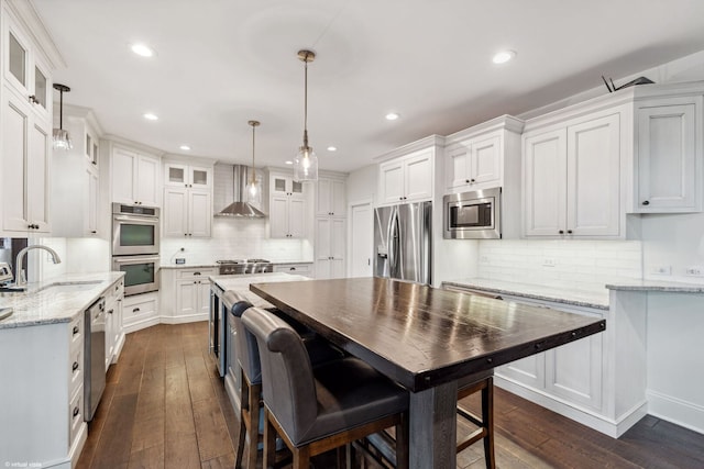 4532 Douglas Rd, Downers Grove, IL 60515 - kitchen with stainless steel appliances, wall chimney exhaust hood, a sink, white cabinets, and recessed lighting