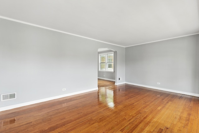 12137 S Perry Ave, Chicago, IL 60628 - spare room with arched walkways, ornamental molding, baseboards, and wood finished floors