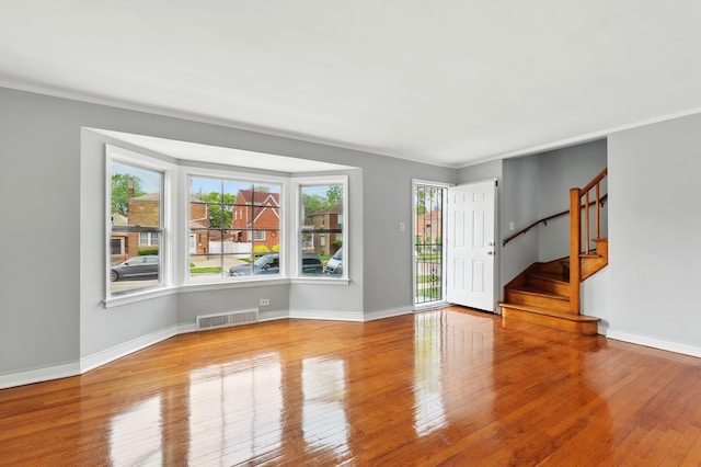 12137 S Perry Ave, Chicago, IL 60628 - unfurnished room featuring healthy amount of natural light, hardwood / wood-style flooring, stairs, baseboards, and crown molding