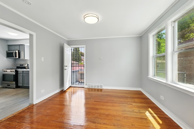 12137 S Perry Ave, Chicago, IL 60628 - empty room with healthy amount of natural light, light wood-style flooring, crown molding, and baseboards