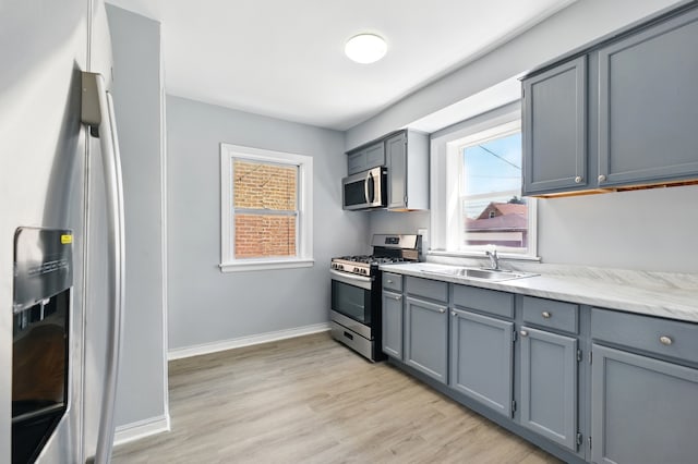 12137 S Perry Ave, Chicago, IL 60628 - kitchen featuring stainless steel appliances, a sink, gray cabinetry, and light wood finished floors