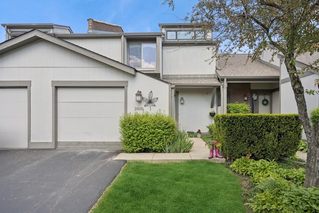 2618 Smith St, Rolling Meadows, IL 60008 - view of front of house featuring asphalt driveway, a garage, roof with shingles, and a chimney
