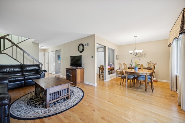 2618 Smith St, Rolling Meadows, IL 60008 - living area with stairs, light wood-style flooring, a chandelier, and baseboards
