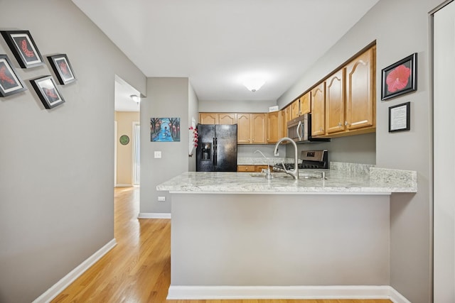 2618 Smith St, Rolling Meadows, IL 60008 - kitchen with stainless steel appliances, a peninsula, light wood-style flooring, baseboards, and light stone countertops
