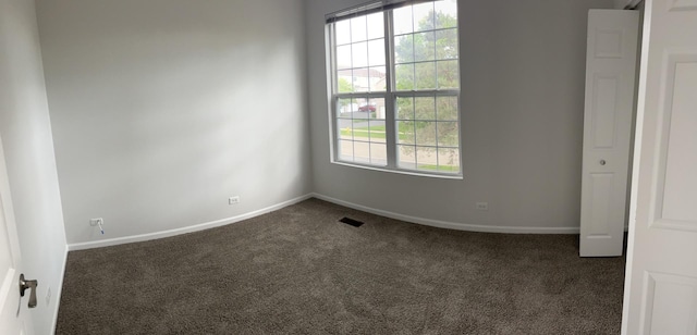empty room featuring carpet floors and baseboards