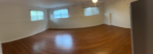 empty room with baseboards and wood finished floors
