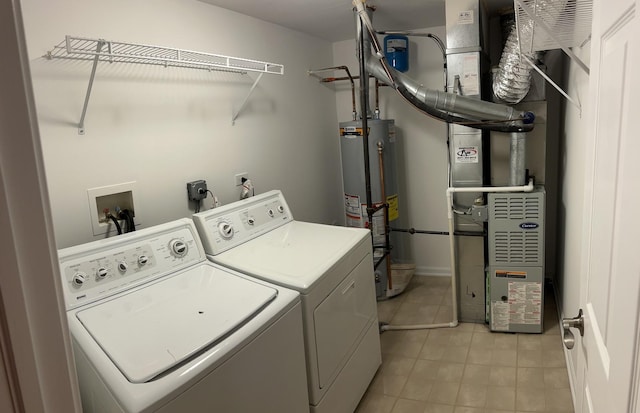 laundry area with washing machine and clothes dryer, water heater, and light tile patterned floors