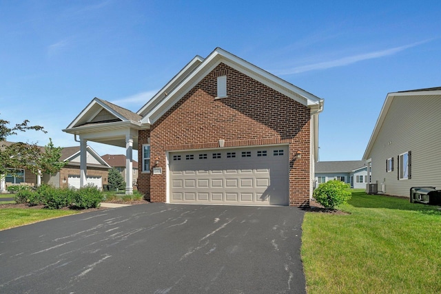 25626 S Geraldine Ct, Channahon, IL 60410 - traditional-style house featuring brick siding, a front yard, central AC unit, and asphalt driveway