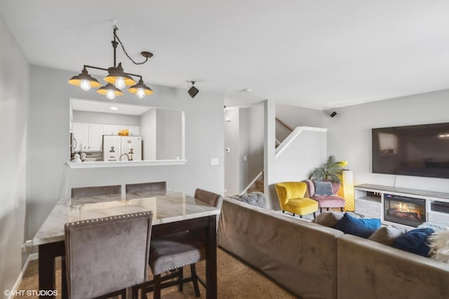 39642 N Warren Ln Unit 0, Beach Park, IL 60083 - dining room featuring stairway, carpet flooring, a chandelier, and a glass covered fireplace