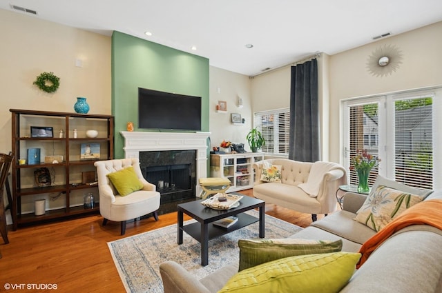 living area featuring wood finished floors, a premium fireplace, and recessed lighting