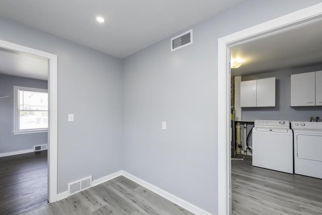 laundry room featuring cabinet space, washing machine and clothes dryer, light wood-style floors, baseboards, and recessed lighting