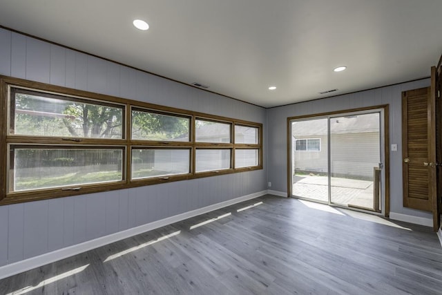 spare room with wood finished floors, baseboards, and recessed lighting