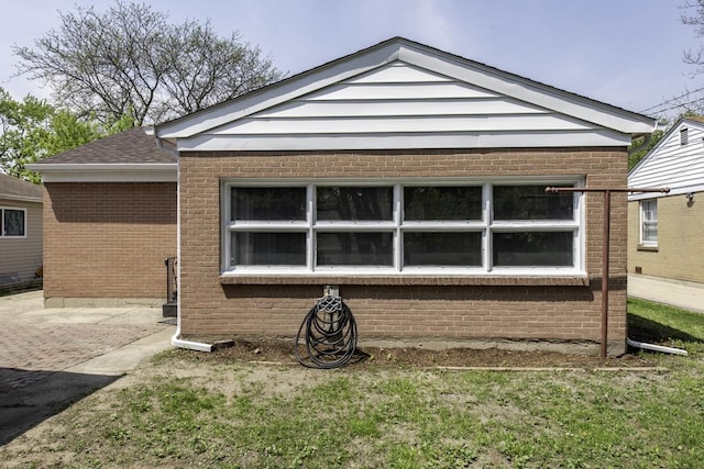 rear view of house featuring brick siding, a yard, and a patio area