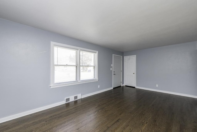 spare room with dark wood finished floors and baseboards