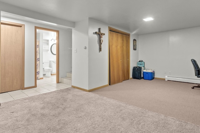 finished basement featuring baseboard heating, carpet, baseboards, and tile patterned flooring