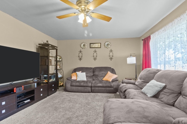 carpeted living area with ceiling fan
