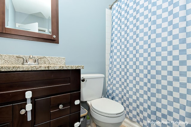 full bath featuring toilet, vanity, and a shower