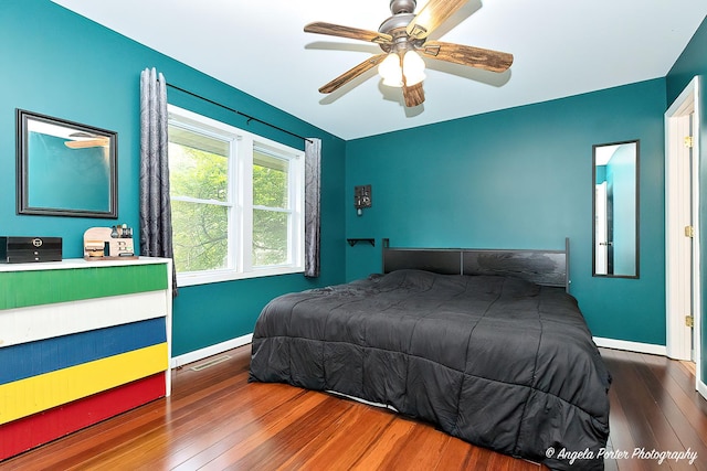 bedroom featuring wood finished floors, baseboards, and ceiling fan