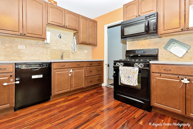 kitchen with black appliances, light countertops, dark wood-type flooring, and tasteful backsplash