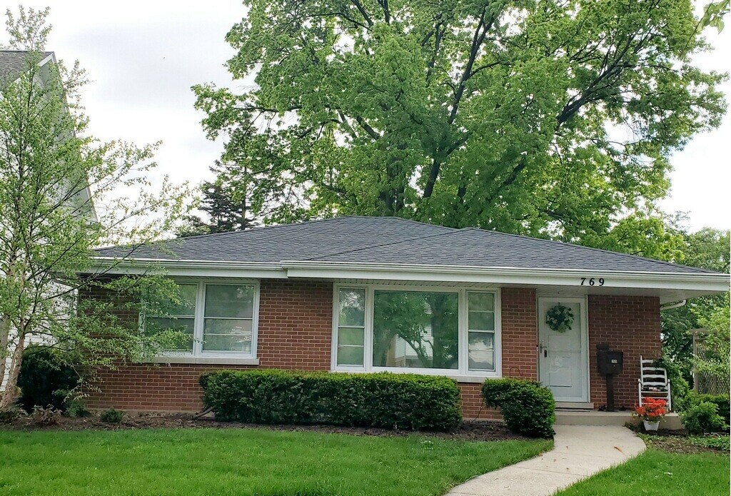 view of front of property featuring brick siding and a front yard