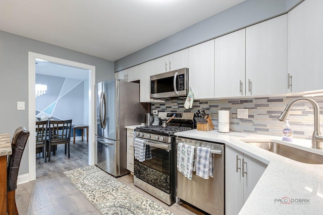 225 Lake Blvd Unit 546, Buffalo Grove, IL 60089 - kitchen featuring stainless steel appliances, a sink, backsplash, and light wood-style flooring