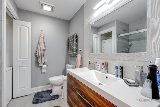 225 Lake Blvd Unit 546, Buffalo Grove, IL 60089 - bathroom with a shower stall, vanity, toilet, baseboards, and stacked washer and clothes dryer