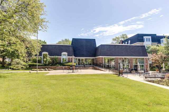 225 Lake Blvd Unit 546, Buffalo Grove, IL 60089 - rear view of property with a yard, brick siding, a patio, roof with shingles, and mansard roof