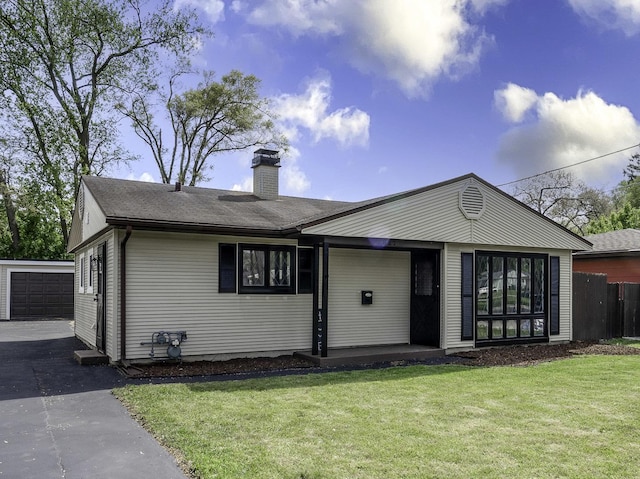 single story home with a chimney and an outdoor structure
