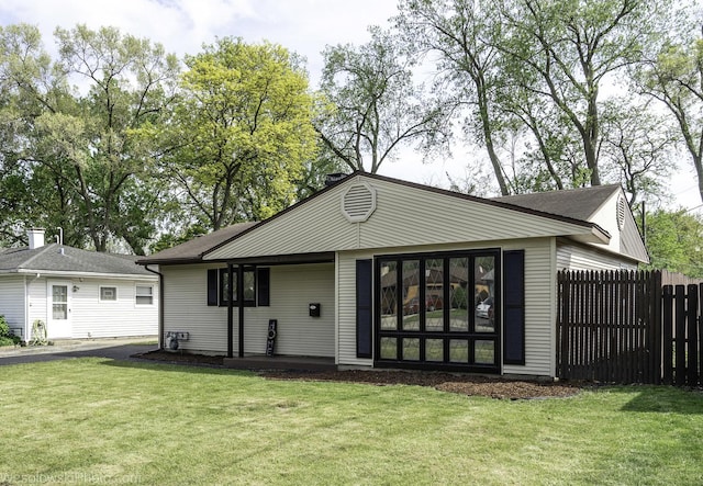 rear view of property featuring asphalt driveway