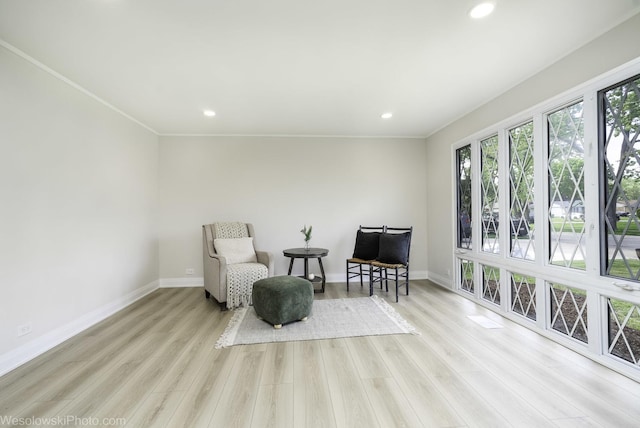 living area featuring baseboards, wood finished floors, recessed lighting, and crown molding