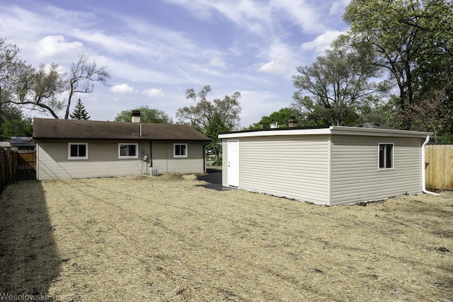 rear view of house featuring fence