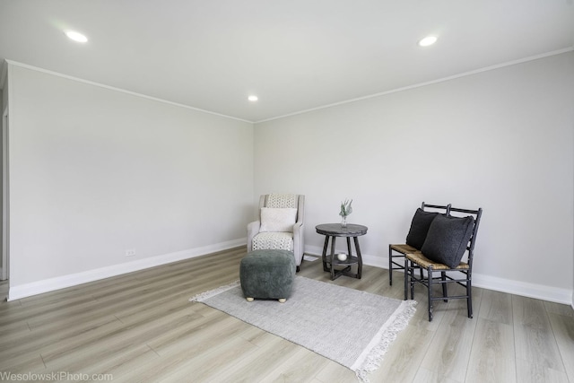 sitting room featuring wood finished floors, ornamental molding, baseboards, and recessed lighting