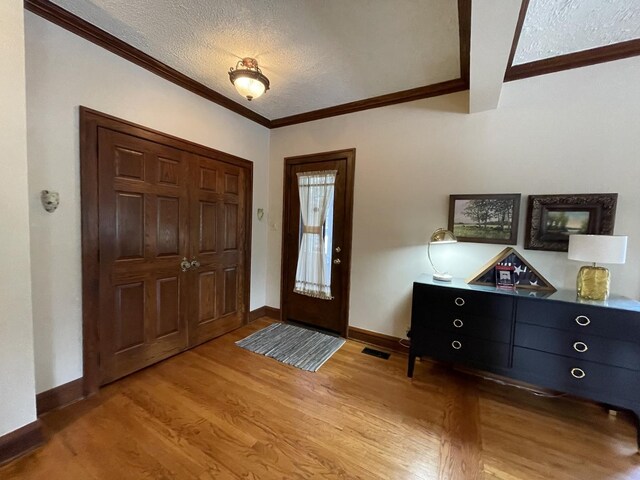 9600 W Shore Dr, Oak Lawn, IL 60453 - foyer entrance featuring a textured ceiling, ornamental molding, light wood-type flooring, and baseboards