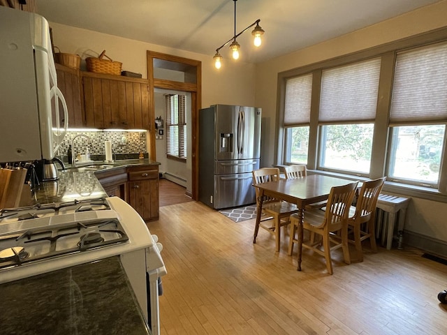 9600 W Shore Dr, Oak Lawn, IL 60453 - kitchen with stainless steel fridge, range with gas stovetop, baseboard heating, a sink, and light wood-style flooring