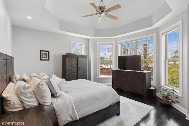 3447 N Whipple St, Chicago, IL 60618 - bedroom featuring dark wood finished floors, baseboards, a tray ceiling, and a ceiling fan