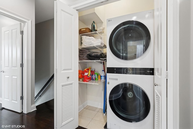 3447 N Whipple St, Chicago, IL 60618 - washroom with stacked washer and clothes dryer, tile patterned floors, and baseboards