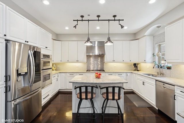 3447 N Whipple St, Chicago, IL 60618 - kitchen with appliances with stainless steel finishes, wall chimney range hood, a sink, white cabinetry, and dark wood-style floors