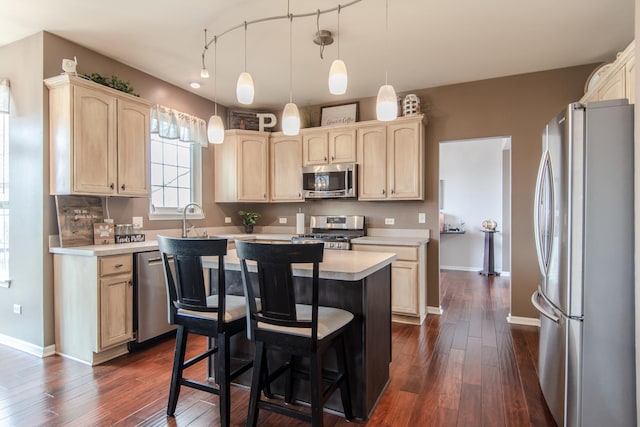 kitchen featuring appliances with stainless steel finishes, light countertops, dark wood finished floors, light brown cabinets, and a kitchen island