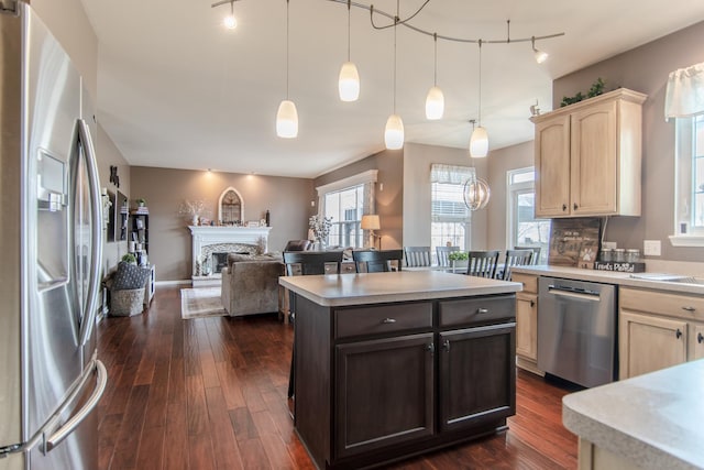 kitchen featuring stainless steel appliances, rail lighting, light countertops, and light brown cabinetry