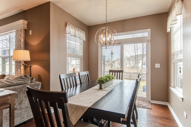 dining area with a chandelier, wood finished floors, and baseboards